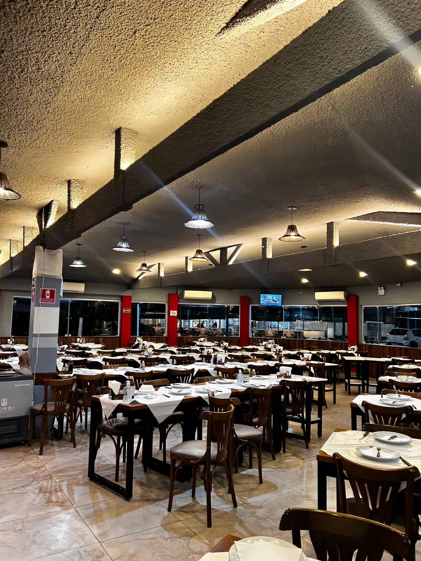 Amplo salão com mesas e janelas do Smarc Grill